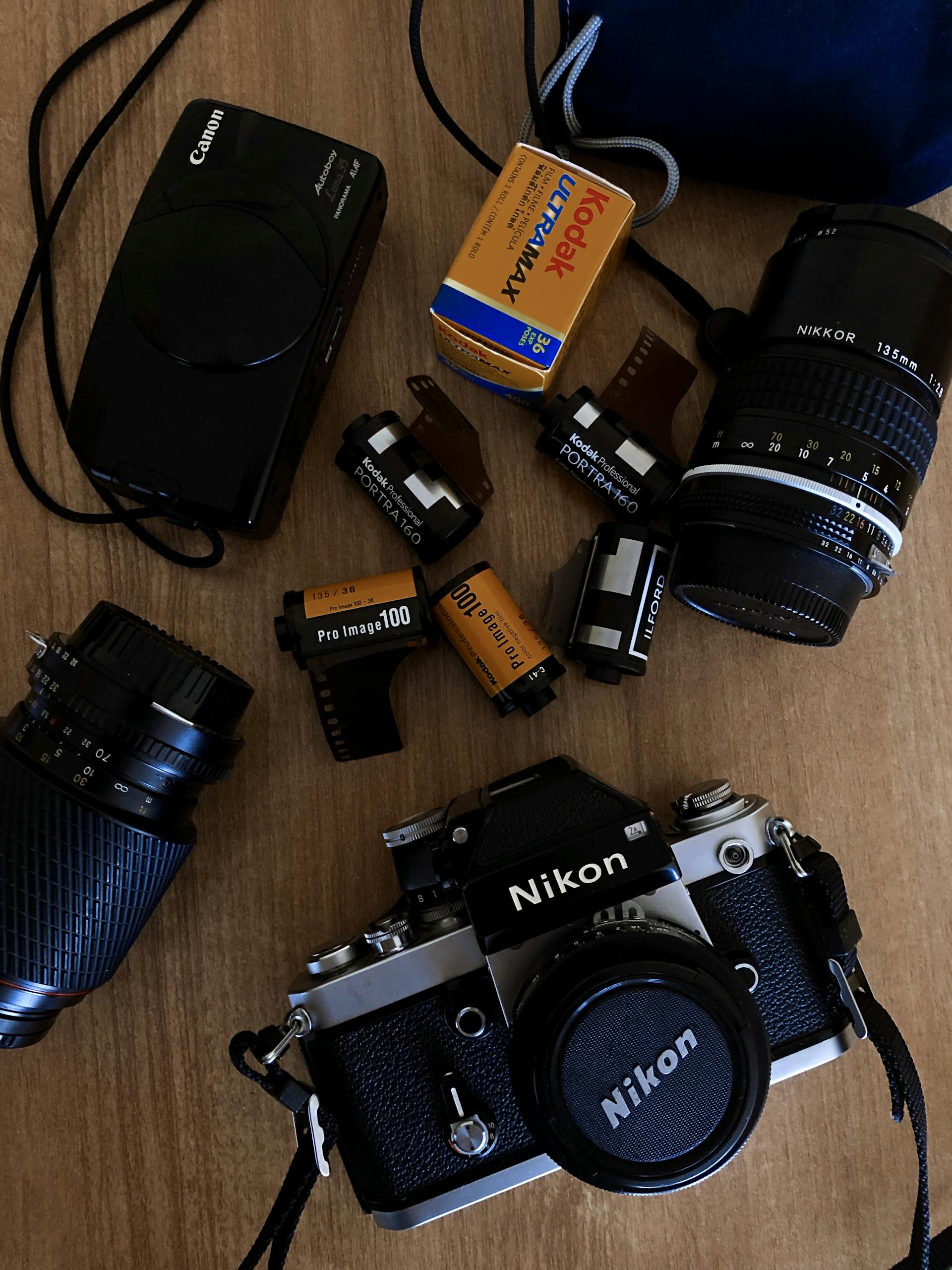 A nostalgic collection of vintage cameras and film rolls on a wooden surface, capturing classic photography.